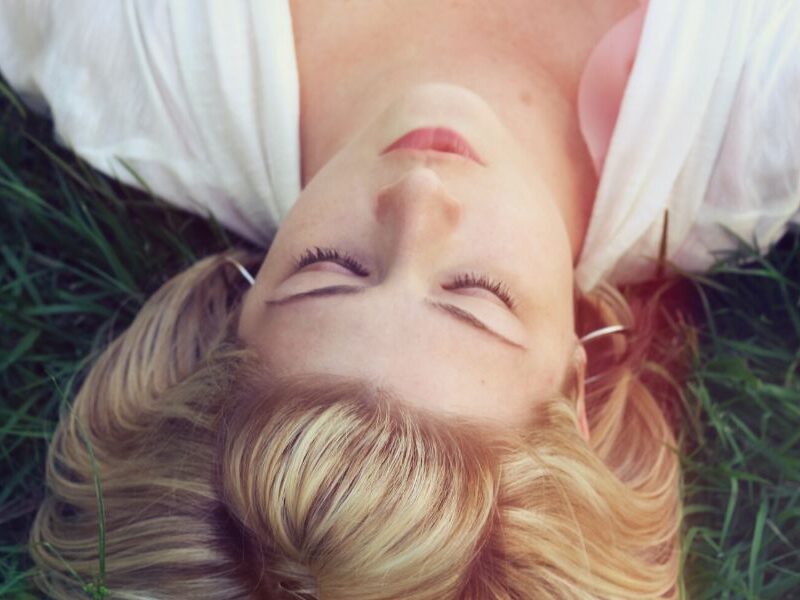 girl lying in grass with eyes closed