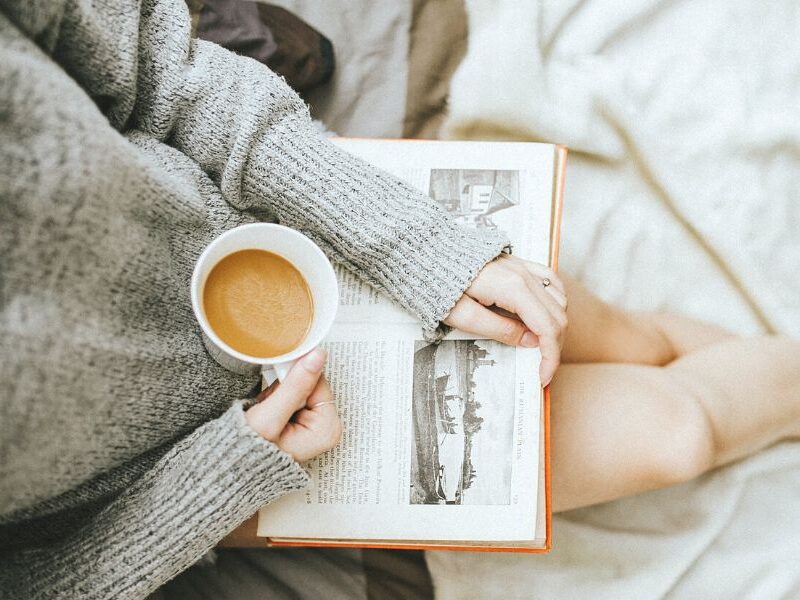 woman reading book with coffee for winter self-care ideas