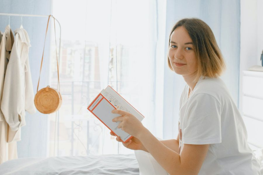 woman reading in bed about ways to reduce stress