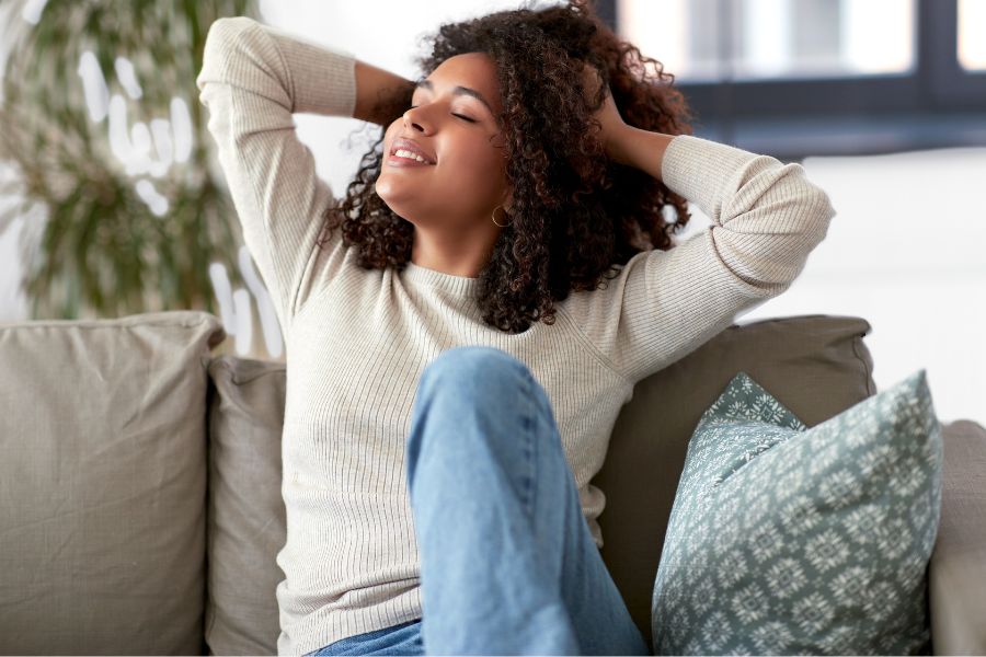 woman relaxing on couch with eyes closed