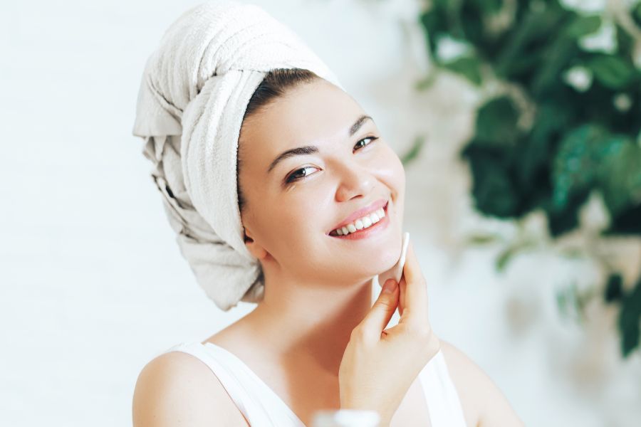 woman applying face toner after a bath