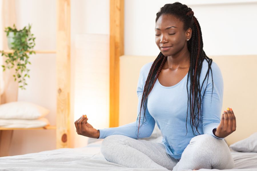 woman wearing blue nightsuit meditating in autumn morning