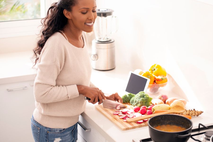 happy woman cooking with help of phone