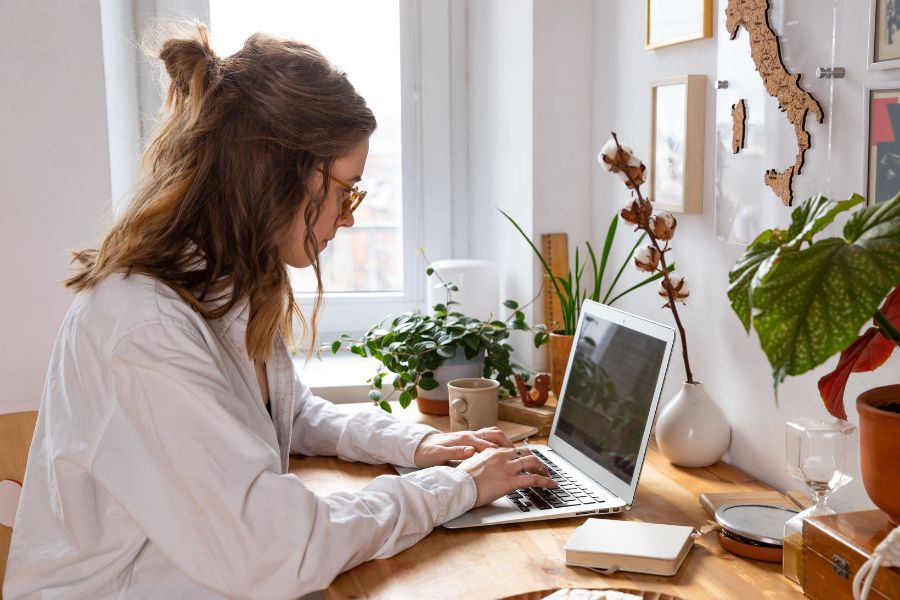 woman wearing spectacles working on laptop on desk