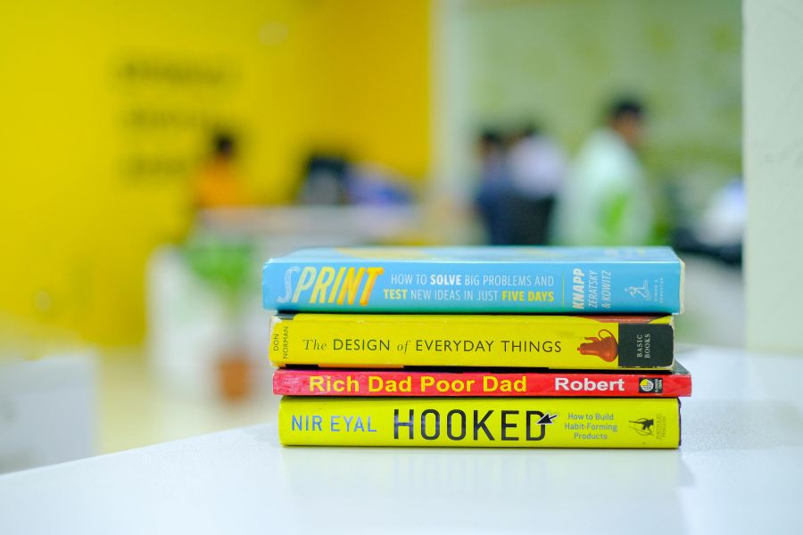 four books on table: sprint, the design of everyday things, rich dad poor dad, hooked