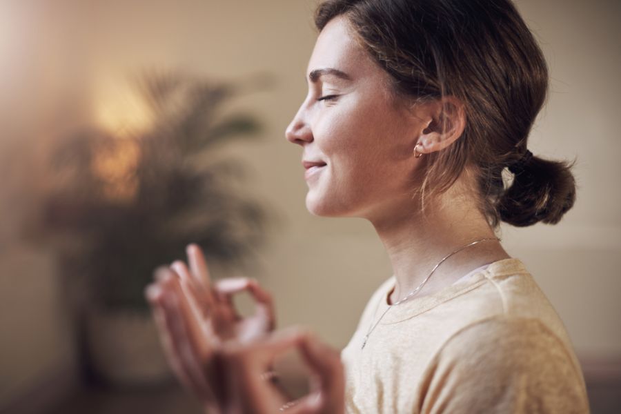 smiling woman meditating with eyes closed