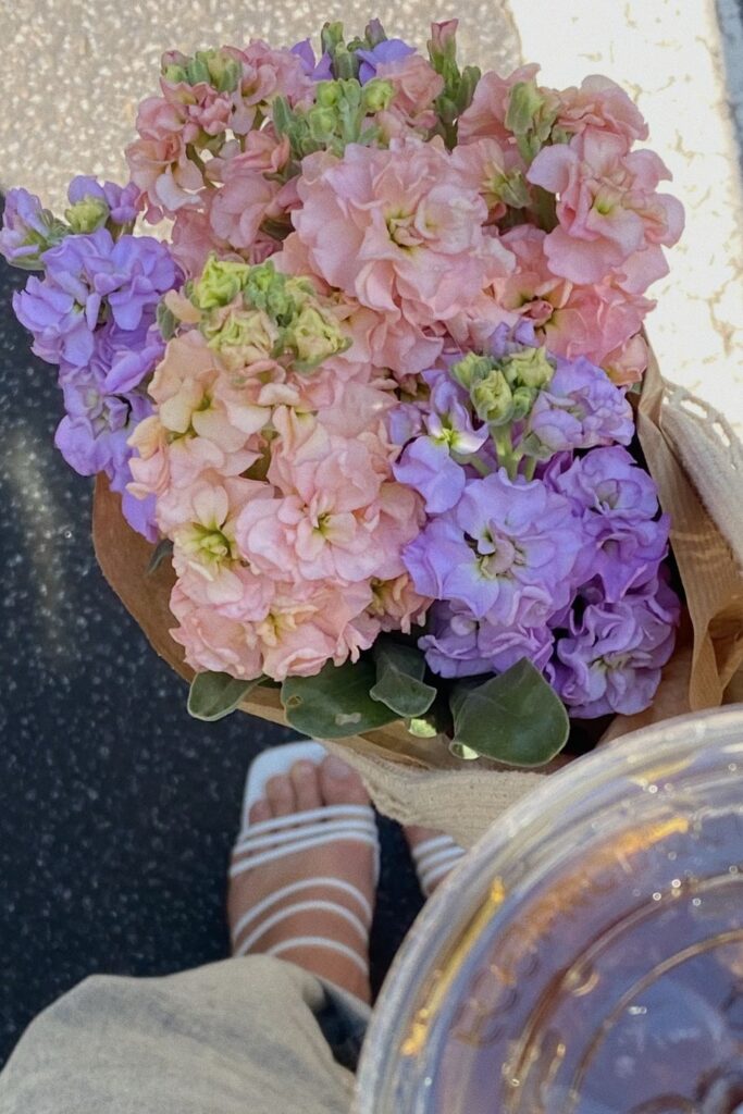 holding pink and purple flowers