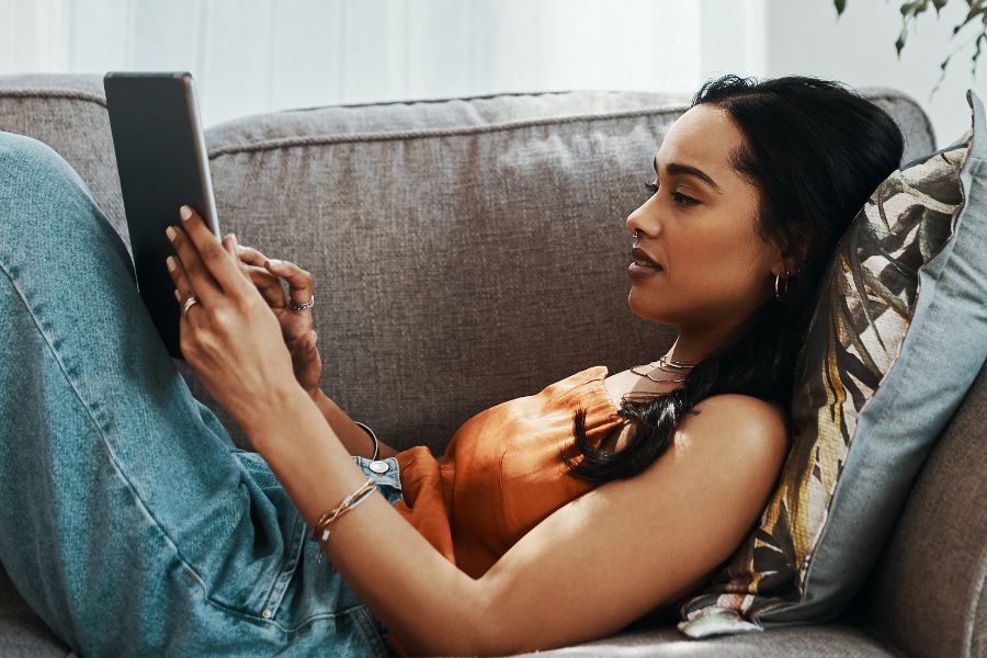 woman on sofa watching something on tablet