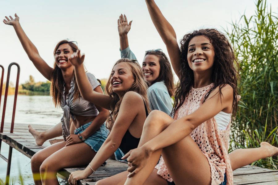 four women enjoying on lakeside
