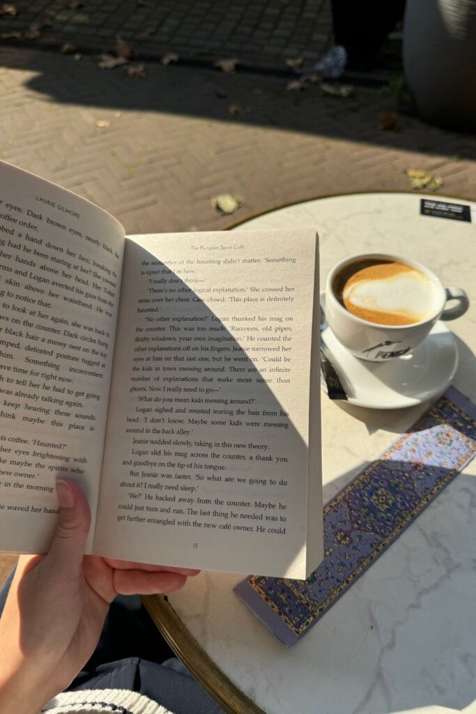 reading a book outdoors with coffee on table