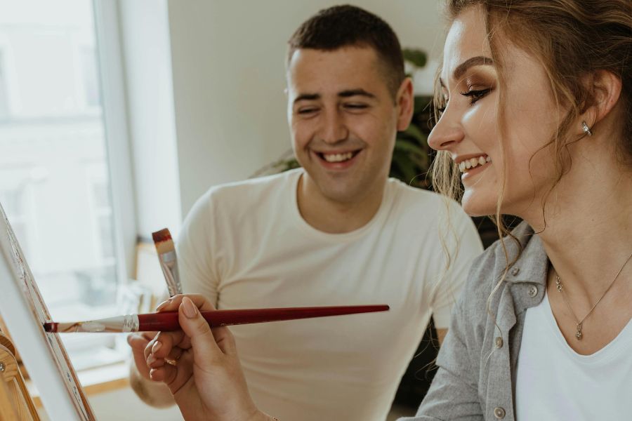 woman and man painting while laughing