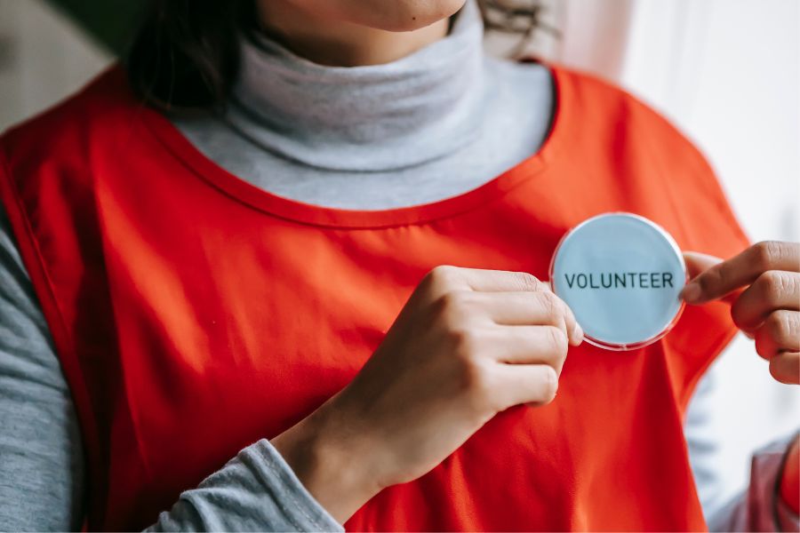 woman wearing volunteer badge on orange vest