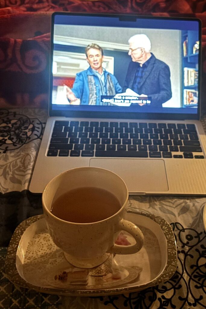 OMITB playing in laptop with green tea in tray