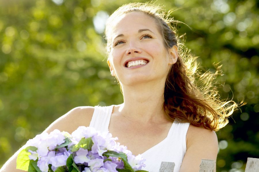 woman carrying lavender flowers smiling big