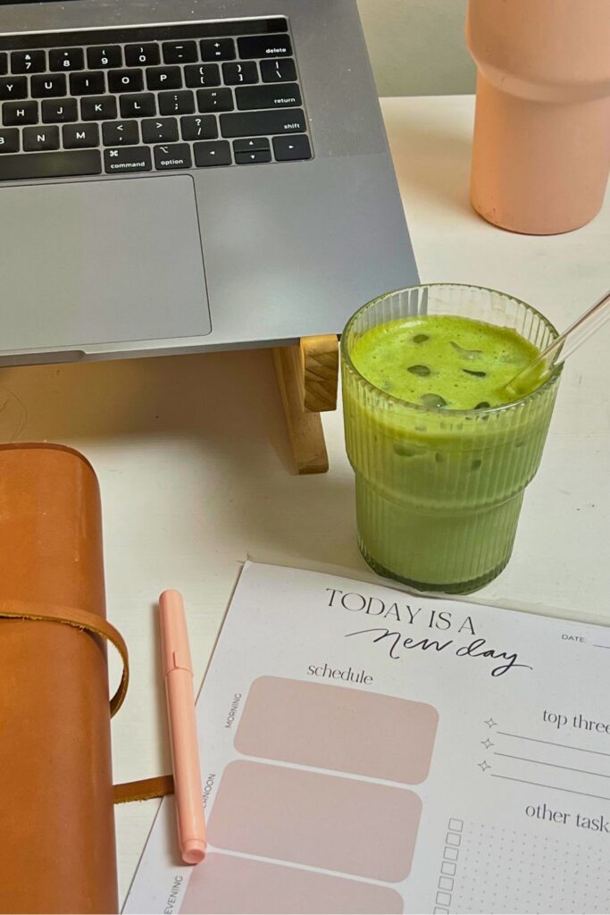 daily planner, pen, matcha, laptop on table