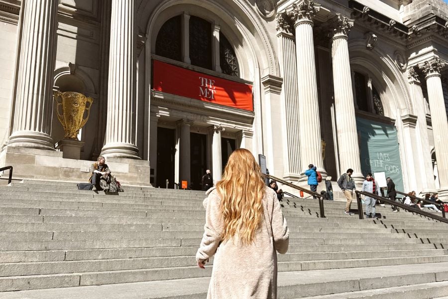 back view of a woman climbing the stairs to a museum