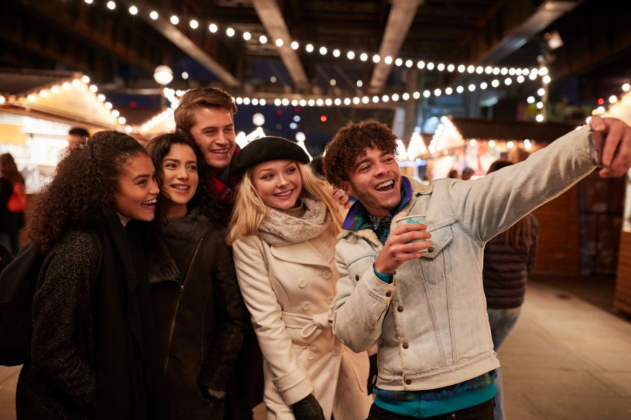 five friends clicking selfie in a winter market