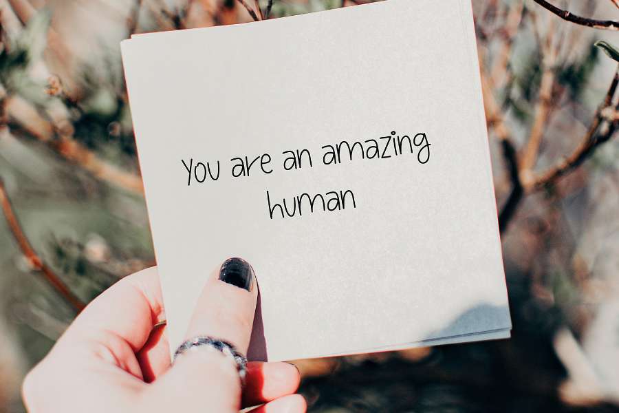 holding a note saying 'you are an amazing human'
