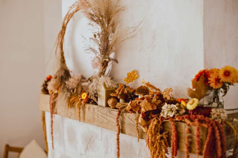 fall decor with dry leaves, wreath, and flowers