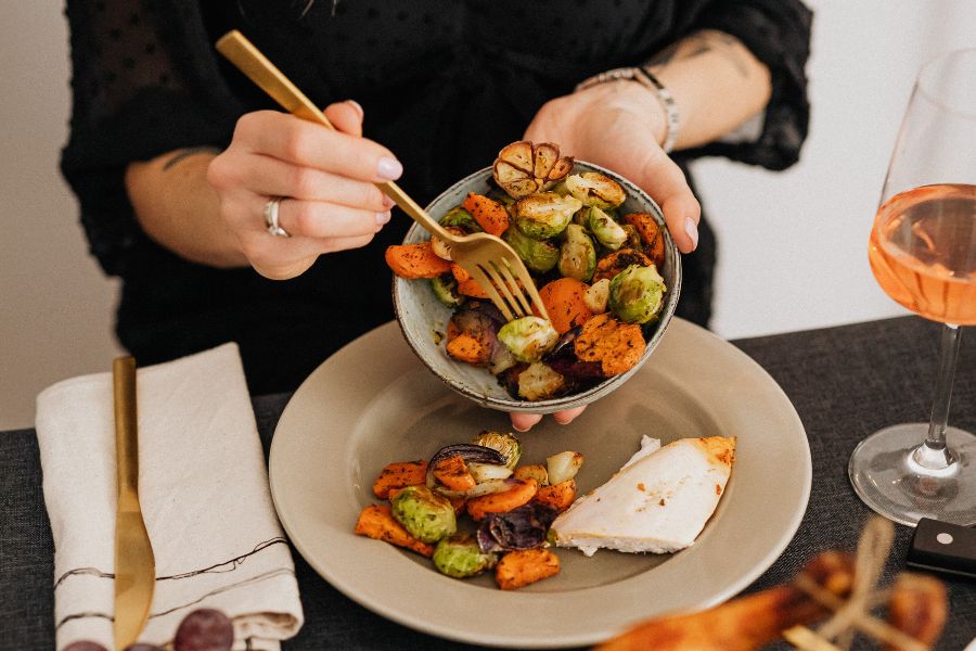 serving fried veggies from a bowl and fork into a plate