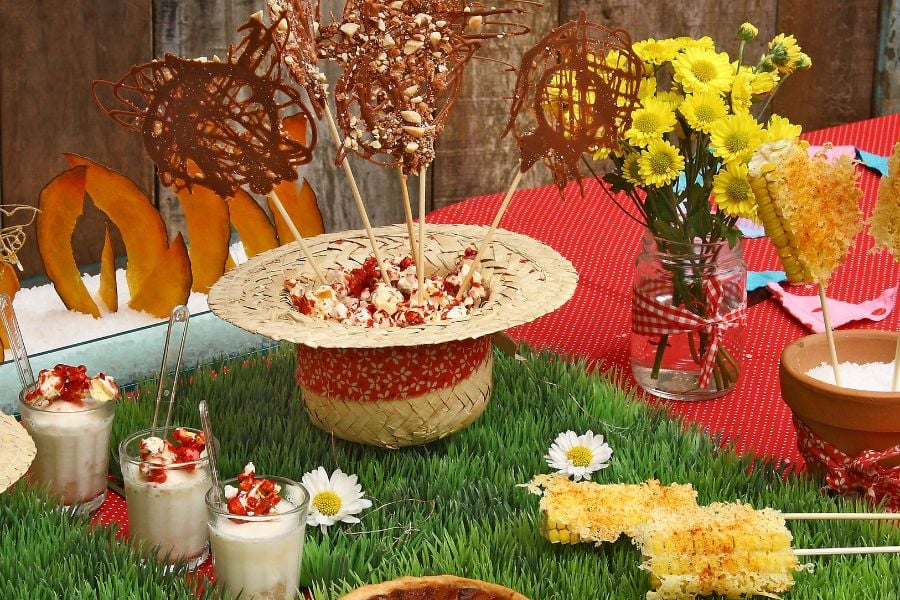 summer party spread with milkshakes, sunfllowers, corn, and grass decor
